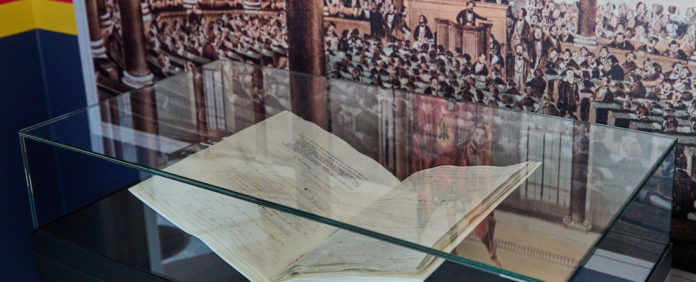 Die originale Paulskirchenverfassung vor einem Bild der Nationalversammlung in der Frankfurter Paulskirche. Foto: epd/F